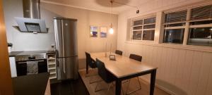 Una cocina con una mesa de madera y un refrigerador. en Apartment centrally located in Tromsø with free parking, en Tromsø