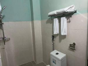 e bagno con servizi igienici, doccia e asciugamani. di Pickyard Guest House a Phumĭ Prêk Chrey