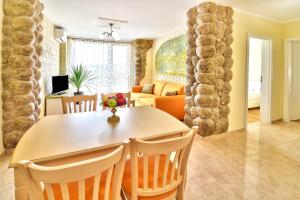 a dining room and living room with a table and chairs at Sirena Palace Family Hotel in Obzor