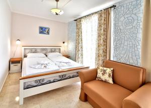 a bedroom with a bed and a chair and a window at Sirena Palace Family Hotel in Obzor
