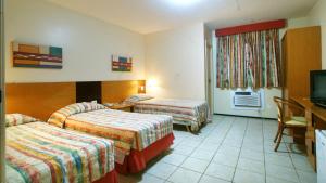 a hotel room with two beds and a television at Aquaville Aquiraz Hotel in Aquiraz +22 photos