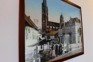 a framed picture of a city street with a church at B&B Laguna in Đakovo