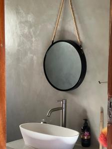 a mirror hanging above a sink in a bathroom at lodge3a in Ponta do Ouro