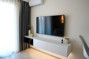 a living room with a television on a white wall at Nexa Suite in Komotini +46 photos