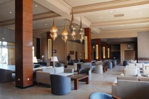 a lobby with couches and tables and chandeliers at Oasis Palm Hotel in Guelmim