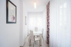 une salle à manger avec une table et des chaises blanches dans l'établissement Casa Fermecata, à Vişeu de Sus