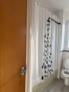 een badkamer met een douchegordijn en een toilet bij Charming Edinburgh Apartment with Electric Heating Free WiFi in Edinburgh