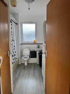een badkamer met toilet, wastafel en raam bij Charming Edinburgh Apartment with Electric Heating Free WiFi in Edinburgh