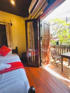 Ένα ή περισσότερα κρεβάτια σε δωμάτιο στο Luang Prabang Champa Villa Hotel