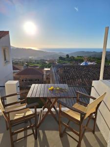 een houten tafel en 2 stoelen op een balkon bij balconi 1911 - Traditional house in Ydroussa, Samos in Ydroússa