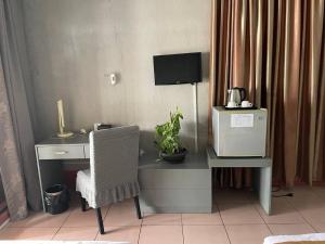 una scrivania con computer, sedia e TV di Pickyard Guest House a Phumĭ Prêk Chrey Altre 17 foto