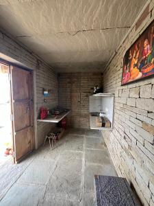 a room with a brick wall with a table and a desk at Virasat homestay in Chanderi