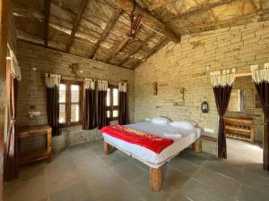 a bedroom with a large bed in a brick wall at Virasat homestay in Chanderi