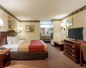 a hotel room with a bed and a flat screen tv at Econo Lodge Grenada in Grenada
