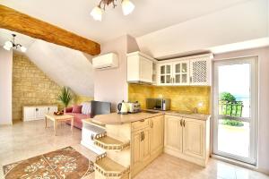 a kitchen with white cabinets and a table at Sirena Palace Family Hotel in Obzor