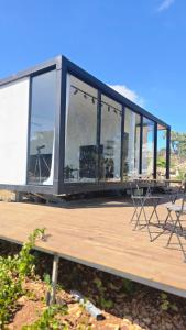 een gebouw met ramen en stoelen op een houten dek bij Goshen in ‘Isfiyā