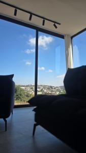 een woonkamer met een bank en een groot raam bij Goshen in ‘Isfiyā