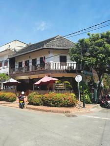 a building with a motorcycle parked in front of it at Luang Prabang Champa Villa Hotel in Luang Prabang