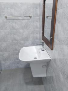 ウナワトゥナにあるHirudee Villaの白い洗面台と鏡のあるバスルーム