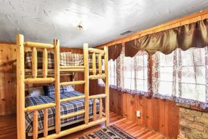 two bunk beds in a room with wooden walls at Rare Log Cabin Treasure Close to Grand Canyon Now with Wi-Fi in Parks