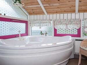 eine große Badewanne in einem Badezimmer mit rosa Wänden in der Unterkunft 8 person holiday home in Glesborg in Fjellerup