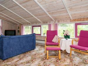ein Wohnzimmer mit lila Stühlen und einem Tisch in der Unterkunft 8 person holiday home in Glesborg in Fjellerup
