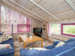 ein Wohnzimmer mit einem blauen Sofa und einem Tisch in der Unterkunft 8 person holiday home in Glesborg in Fjellerup