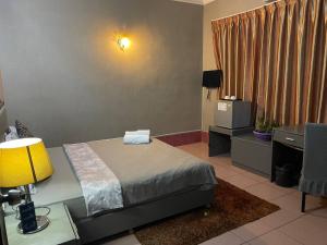 una camera da letto con un letto e una scrivania con una lampada di Pickyard Guest House a Phumĭ Prêk Chrey