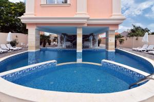 a swimming pool in the middle of a house at Sirena Palace Family Hotel in Obzor
