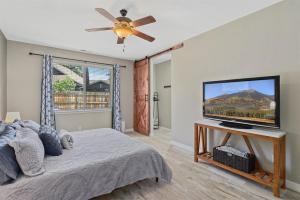 a bedroom with a bed with a flat screen tv at Sublime Mountain Retreat Pool Table Fire-Pit Arcade Game Ideal Location w Central AC in Flagstaff