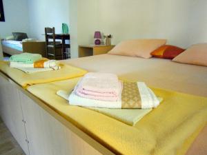 two beds with towels sitting on top of them at Room Bea Rastoke in Slunj