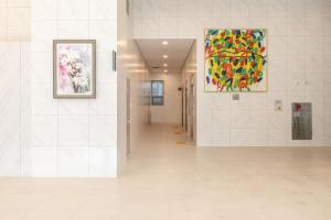 een hal in een gebouw met schilderijen aan de muren bij Richeville Signature Hotel and Residence in Puwŏl-li