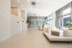 een kantoorlobby met witte meubels en grote ramen bij Richeville Signature Hotel and Residence in Puwŏl-li