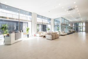 een grote lobby met witte meubels en grote ramen bij Richeville Signature Hotel and Residence in Puwŏl-li +30 foto's