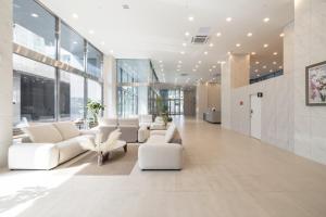 een lobby met witte meubels en grote ramen bij Richeville Signature Hotel and Residence in Puwŏl-li
