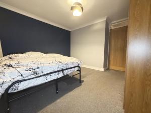 a bedroom with a bed with a blue wall at Bright Double Room in Wellingborough in Harrowden