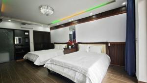 a bedroom with two beds with white sheets at Hana Homestay KGR in Xuan Dam +6 photos