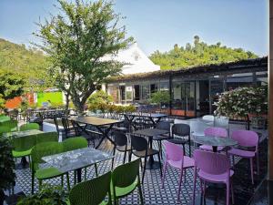 an outdoor seating area with tables and colorful chairs at Hana Homestay KGR in Xuan Dam