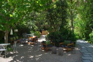a group of chairs and tables in a park with trees at Alma Barcelona GL in Barcelona