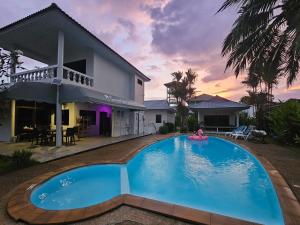 een zwembad voor een huis bij Sansuko Ville Panwa in Ban Bo Rae