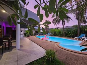 een zwembad met een vrouw in een roze badpak in een resort bij Sansuko Ville Panwa in Ban Bo Rae