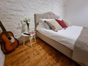 a bedroom with a bed with a guitar and a table at Central House Craiova in Craiova