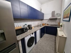 a small kitchen with blue cabinets and a sink at Central House Craiova in Craiova +6 photos
