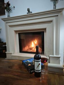 a bottle of wine next to a glass of red wine at Central House Craiova in Craiova