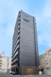 a tall building with a sign on the side of it at Apartment Hotel 11 Nippombashi in Osaka