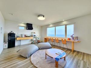 a living room with a couch and a table at 「淡路島一棟貸宿　野うさぎ 」高台から海を望む貸別荘！2023年新築離れの素泊まり in Noda
