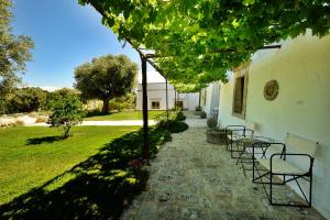 a pathway with chairs and a table and a building at Masseria Trulli e Vigne in Martina Franca