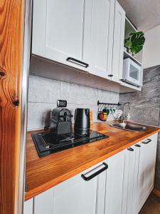 eine Küche mit weißen Schränken und einem Herd mit Backofen in der Unterkunft FRONT DE NEIGE MONTGENEVRE in Montgenèvre