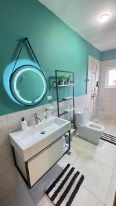 Un baño con lavabo, espejo e inodoro. en WRparaiso, en Boca Chica