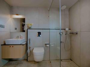 a bathroom with a shower and a toilet and a sink at Nine, Boutique hotel with luxury room stay, mysore in Mysore